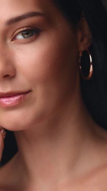 Yüzüne nazikçe dokunan, zarif, cilt bakımı ve kozmetik güzelliği yüksek kaliteli bir tanıtım videosundaki güzel, beyaz bir kadının yakın plan fotoğrafı..