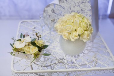 Dekoratif bir masa üzerinde zarif beyaz gül çiçek aranjmanları, düğünler, yıldönümleri ve diğer sofistike etkinlikler için mükemmel. Zarafet, romantizm ve son moda dekorlar için ideal.