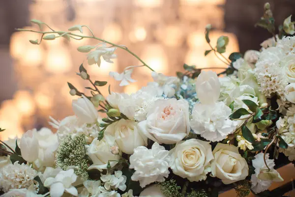 Zarif beyaz bir çiçek süsü. İçinde güller, laleler ve ortancalar var. Zarif düğünler için mükemmel. Romantizm, lüks ve kutlama temaları için ideal, sofistike çiçeklerin sergilenmesi
