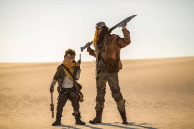 Kıyamet sonrası anne ve oğlu çorak çölde silahlarla poz veriyorlar. Kavramsal bilim kurgu, hayatta kalma ve fantezi tanıtım imajı. Film afişleri, macera reklamları ve temalı içerik için harika.