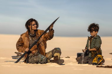 Kadın büyük kılıcı incelerken çocuk da çöl kampında teçhizatı inceliyor. Sinema fantastik hikaye anlatımı, film temaları ve temalı tanıtım programları için yüksek kaliteli bilim kurgu konsepti görüntüsü.