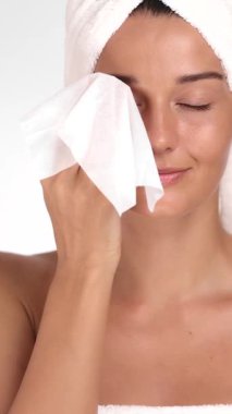 Kusursuz derisi olan beyaz kadın temizleyici mendil kullanarak göz makyajını temizliyor. Yumuşak cilt bakımları, günlük güzellik rutinleri ve kozmetik ürünler reklam kampanyaları için kavram.