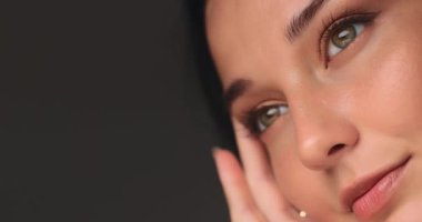 Altın rengi göz makyajı, parıldayan doğal ten ve yumuşak el hareketi olan bir kadının yüksek kalite güzelliği. Cilt bakımı kampanyaları, kozmetik reklamları ve yazı işleri için mükemmel..