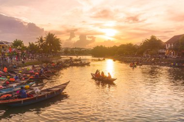 Güneş batarken Hoi An, Vietnam 'da geleneksel teknelerin manzarası. Parlayan fenerler ve yansımalarla. Seyahat, kültür, yaşam tarzı ve editoryal stok içeriği için mükemmel..
