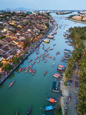 Hoi An, Vietnam 'ın yüksek açılı insansız hava aracı görüntüsü fener festivali sırasında turist ve teknelerle doluydu. Yayımsal kullanım, afiş reklamları ve Güneydoğu Asya seyahatleri için mükemmel bir görsel..