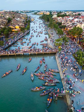Fener teknesi festivali sırasında Hoi An 'ın çarpıcı bir dikey görüntüsü. Canlı kalabalıklar, renkli tekneler ve zengin Vietnam kültürü sergileniyor. Seyahat reklamları ve makaleler için ideal..