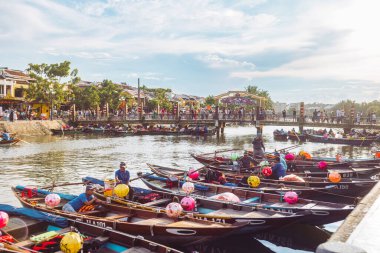 Renkli fener tekneleri Hoi An, Vietnam 'da nehir kıyısında huzur içinde rıhtıma yanaşıyor. Seyahat, turizm, editör ya da kültür temalı stok fotoğrafçılığı için ideal güneş ışığı altında..