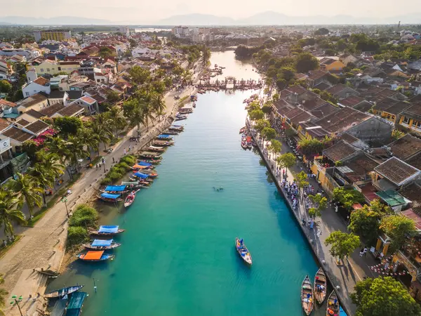 Hoi Ans 'ın Vietnam' daki nehir kenarı manzaralı renkli tekneler, tarihi binalar ve hareketli caddeler. Seyahat reklamları, turizm reklamları ve kültürel içerik için mükemmel..