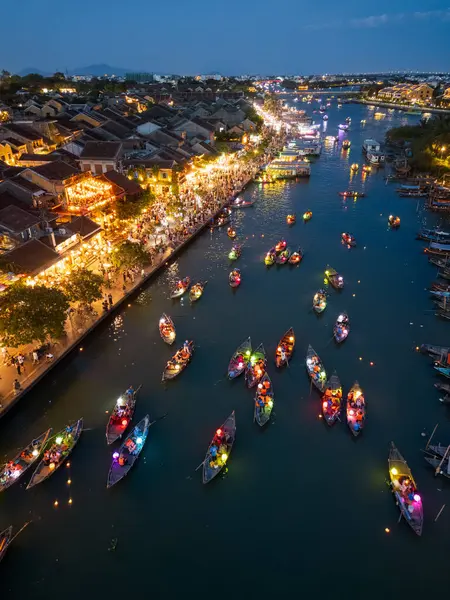 Hoi An 'ın yüksek irtifa manzarası, Vietnam' ın gece parlayan fener tekneleri ve festival zamanı kalabalık caddeleri. Canlı, yüksek kalite bir fotoğraf seyahat, makale ve afiş kullanımı için mükemmel.