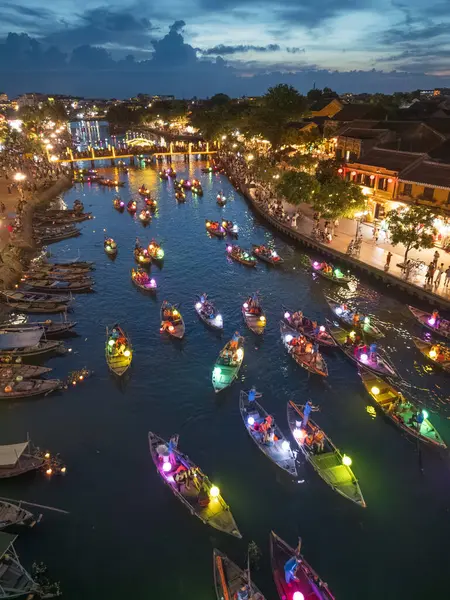 Hoi An, Vietnam 'da büyüleyici bir gece sahnesi, nehir kenarı festivali sırasında renkli fenerlerin altında parlayan geleneksel teknelerle. Seyahat reklamları, makaleler ve kültürel tanıtımlar için mükemmel..