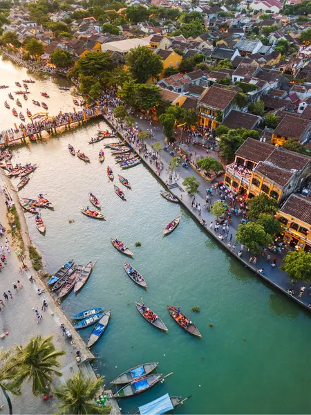 Hoi An, Vietnam 'ın renkli hava görüntüleri nehir teknelerini, tarihi binaları ve işlek caddeleri gösteriyor. Turizm promosyonları, kültürel reklamlar, editoryal özellikler ve seyahat içeriği için harika.