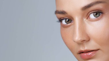 Bir kadının yüzüne çarpıcı bir yakın çekim. İfade eden yeşil gözler, parlak dudaklar ve kusursuz bir cilt. Güzellik reklamları, cilt bakımı markaları, sağlık görselleri ve kozmetik ürün tanıtımları için ideal..
