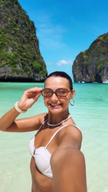 Beyaz bikinili gülümseyen kadın Tayland, Maya Körfezi 'nde selfie çekiyor. Eğlence, gençlik tarzı seyahat, moda, etkili ve yaz tanıtım içeriği için mükemmel bir konsept..