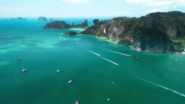 Yengeç 'in Tayland' daki ünlü Railay Sahili 'nin çarpıcı hava görüntüleri. Temiz zümrüt su, dramatik kayalıklar ve hareket eden tekneler bunu seyahat reklamları ve egzotik tanıtım içeriği için ideal hale getiriyor..