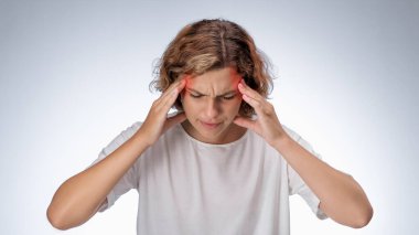 Beyaz kadın iki şakağına da acı dolu bir ifadeyle dokunuyor. Başında migren ağrısı gösteren kırmızı lekeler var. Stres, baş ağrısı veya nörolojik rahatsızlık için kavramsal sağlık imajı.