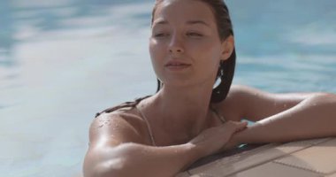 Kafkasyalı kadın, gün ışığı altında havuz kenarında neşeyle gülümsüyor. Cilt bakımı, lüks yaşam tarzı, sağlık ve tatil temalı promosyon içeriği için ideal.