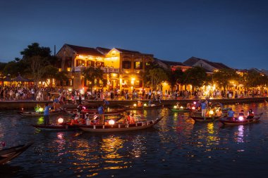 Fener yanan tekneler Hoi An nehri boyunca gece boyunca parlayan binalar ve hareketli bir kalabalıkla süzülür. Seyahat tanıtımları, Asya kültürü reklamları ya da festival konsepti görselleri için ideal. Yüksek kaliteli resim. 