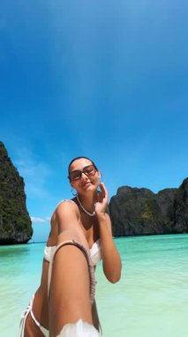Tayland 'ın Phi Phi Adaları' ndaki Maya Körfezi 'nin berrak sularında selfie çeken kendinden emin genç bir kadın. Seyahat, nüfuz sahibi, sosyal medya ve lüks yaz yaşam tarzı videoları için ideal.