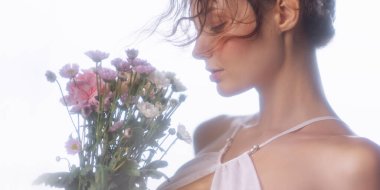 Beyaz, yumuşak iç çamaşırlı, bahar çiçekleriyle süslenmiş beyaz bir kadının zarif portresi. Cilt bakımı, güzellik, romantizm ve moda reklamcılığı için mükemmel..