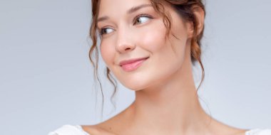 Yüzü parlayan beyaz tenli, gülümseyen beyaz bir kadının geniş afiş portresi. Cilt bakımı, güzellik, sağlık ve kozmetik reklamları için mükemmel..