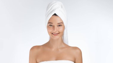 Parlak bir gülümsemesi ve parlak bir cildi olan, havluya sarılı genç bir kadın, taze ve kendinden emin görünüyor. Doğal güzelliği ve sağlıklı ışıltısı bunu cilt bakımı, kaplıca ve sağlık kavramları için mükemmel kılıyor..