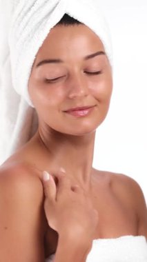 Havluyla gülümseyen, gözleri kapalı, elinde modern duş başlığı tutan güzel bir kadın. Cilt bakımı, spa konseptleri, banyo ürünleri, güzellik rutini veya temiz yaşam tarzı markalaşması için harika..