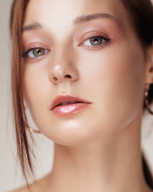Göz makyajı, parlak dudaklar ve parlak cilt ile beyaz bir kadının göz kamaştırıcı yakın çekimi. Kozmetik reklamları, güzellik tanıtımları, cilt bakımı markaları ve makyaj ürünleri için ideal. 