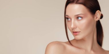 Parlak tenli ve doğal kahverengi saçlı güzel bir kadının minimalist geniş afiş resmi. Kozmetik reklamcılık, güzellik tanıtımı, sağlık kaplıcası veya cilt bakımı için ideal. 