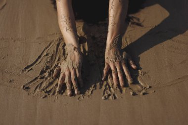 Islak plaj yüzeyine bastırılmış kumlu bir kadının yakın çekim görüntüsü, yaz yaşam tarzı görselleri, tatil tanıtımları, şehvetli plaj kavramları ve doğadan esinlenilmiş reklamlar için ideal..