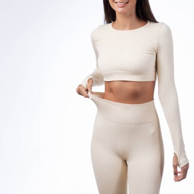 Spor kadının taytlarını düzeltirken çekilmiş bir fotoğraf. Mide rengini ortaya çıkarıyor. Kilo verme kampanyaları, vücut güveni, sağlık yaşam tarzı ya da spor kıyafetleri reklamları için harika..