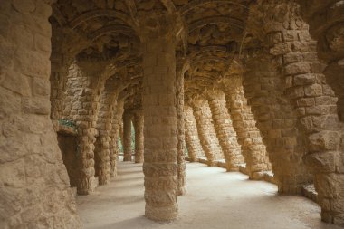 Antoni Gaudi tarafından yaratılan Park Guell, Barcelona 'daki rustik taş sütunların ve kemerlerin mimari detayları. Seyahat blogları, mimari özellikleri ve kültürel turizm kampanyaları için mükemmel..