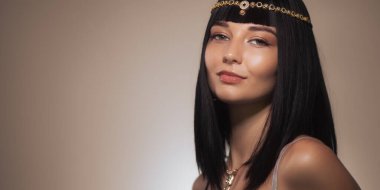 Geleneksel mücevher ve tarihi makyaj içeren Kleopatra esinlenilmiş bir modelin çarpıcı portresi. Moda başyazıları, kültürel temalar ve tarihsel canlandırmalar için idealdir.