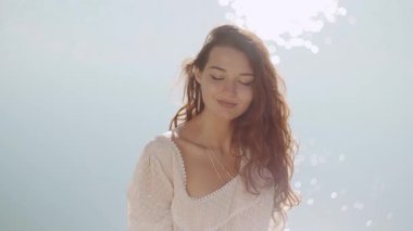 Sahilde duran romantik bir kadının açık hava portresi güzel bir deniz bokeh arka planına karşı. Moda tarzında bronz tenli bir kız. Kamera karşısında. Seyahat tatili, yaz tatili konsepti.