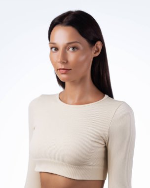 Kendine güvenen genç bir kadının, bej renkli bir bluzla pürüzsüz derisi ve parlak saçları olan stüdyo güzelliği. Moda, güzellik, cilt bakımı ve yaşam tarzı kavramları için yüksek kalite görüntü. 