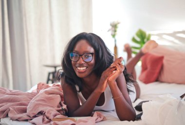 Genç kadın yatakta yatıyor.