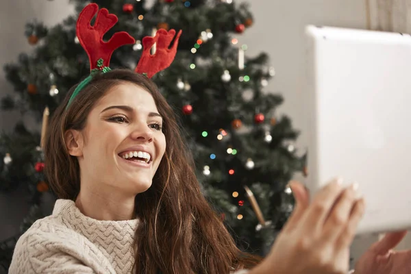 Mujer Joven Sonriente Utiliza Una Tableta Interior Fondo Árbol Navidad — Foto de Stock
