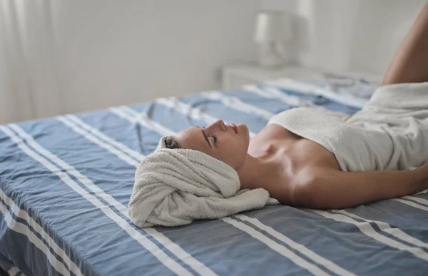 Portret Młodej Kobiety Leżącej Łóżku Głową Pokrytą Ręcznikiem — Zdjęcie stockowe