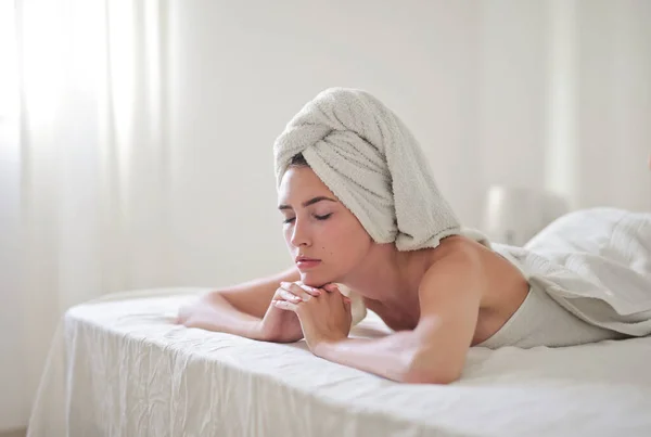 Πορτρέτο Της Νεαρής Γυναίκας Ξαπλωμένη Στο Κρεβάτι Κεφάλι Καλυμμένο Πετσέτα — Φωτογραφία Αρχείου