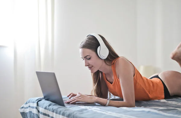 Young Woman Lying Bed Uses Computer Listens Music — Stock Photo, Image
