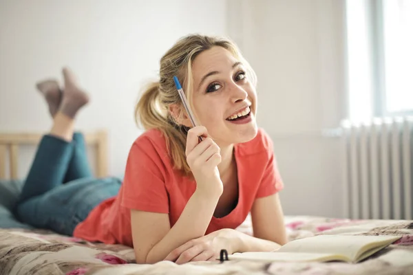 Young Woman Studies Lying Bed — Stock Photo, Image