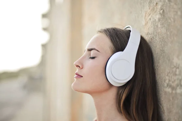 年轻妇女用耳机听音乐 — 图库照片