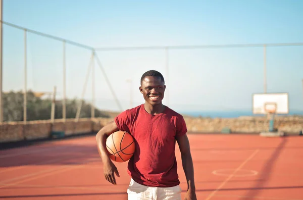 Jonge Lachende Man Een Basketbalveld Stockfoto