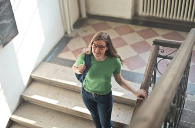 Okulda sırtında sırt çantası olan genç bir kadın.