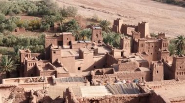 Ksar Kasbah Ait Benhaddou 'nun yüksek açılı görüntüsü. Eski kil evleri olan kırsal bir köy, otantik Güney Fas kır tarzı kerpiç mimarisi. 4k görüntü.