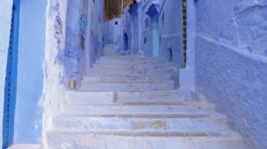 Fas, Chefchaouen 'da mavi merdivenli ve evleri olan sokak detayları. Chefchaouen Medinesi ünlü bir turistik seyahat merkezidir. 4k görüntü.
