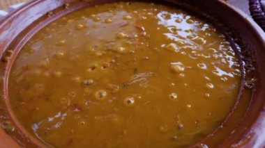 A  traditional Moroccan lentil tajine, tagine, meal served in a clay pot, hot, and sizzling. Traditional Moroccan slow-cooked meal. 4k food background footage.