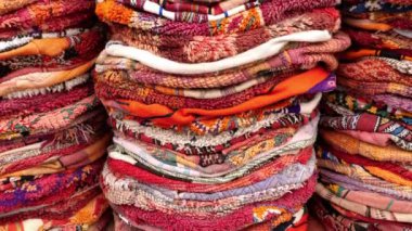 Piles of traditional Moroccan poufs made with carpet fabrics. Moroccan, Berber design, vintage indoor and outdoor floor cushions. Abstract background, 4k footage. 