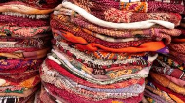 Piles of traditional Moroccan poufs made with carpet fabrics. Moroccan, Berber design, vintage indoor and outdoor floor cushions. Abstract background, 4k footage. 