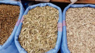 Çay ve yemek için kurutulmuş otlar, sepetlerde, Fas 'ta bir çiftçi pazarında. 4k yemek arkaplan görüntüsü.  