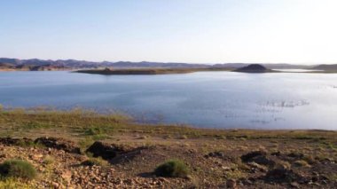 Ouarzazate, Fas 'taki El Mansour Gölü Eddahbi baraj su deposu. Düşük seviyeli su, kuraklık, volkanik dağlar, küresel ısınma, 4K görüntü. 